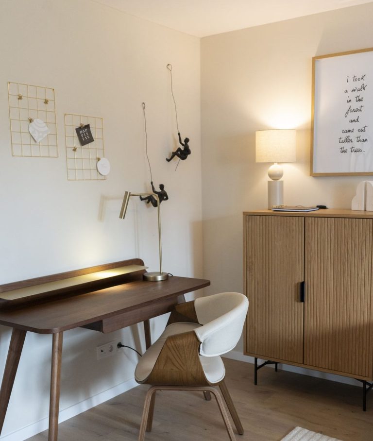 Elegante Tischlampe neben Büchern und dekorativen Objekten auf einer Holzoberfläche.